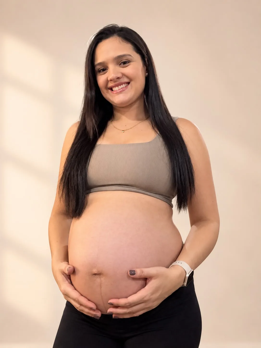 Thaissa Rodrigues grávida, sorrindo e segurando a barriga